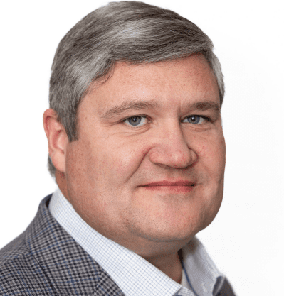 Man with gray hair in checkered suit.