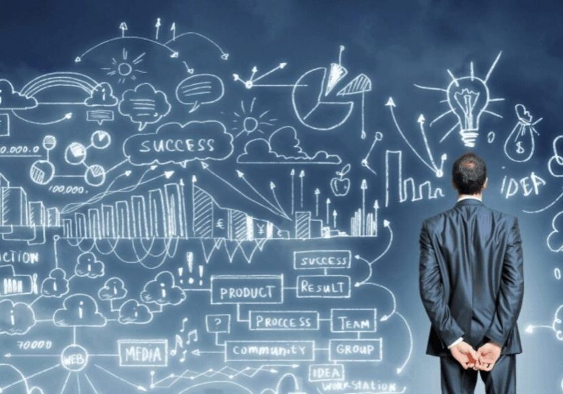 Man contemplating business strategy sketches on wall.